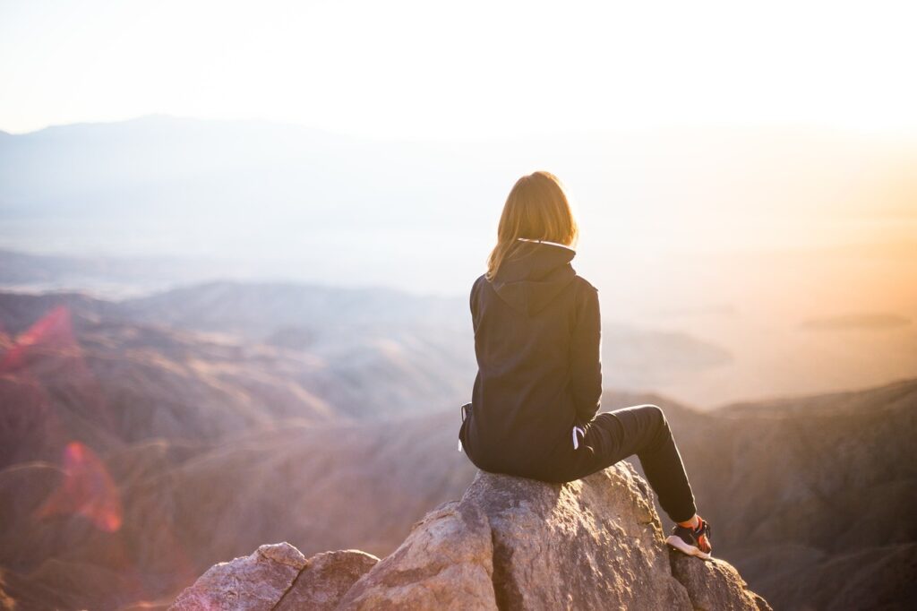 Person auf einem Berggipfel, die den weiten Horizont betrachtet, symbolisch für die Klarheit und innere Führung durch das Zentrum in der Yager Methode